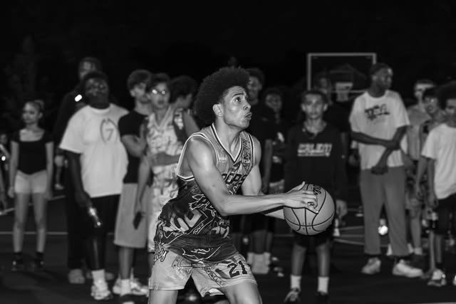 Black-and-white photograph of a basketball player preparing a shot in front of spectators